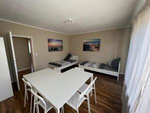 Zimmer mit einem weißen Tisch und Stühlen sowie einem Sofa in der Unterkunft Roxy Ferienwohnung in Rodenbach