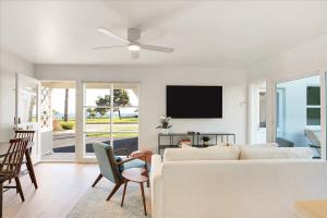 uma sala de estar com um sofá branco e uma ventoinha de tecto em Shoreline Cottage em Santa Bárbara