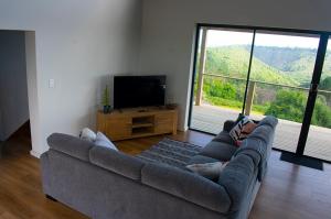 a person laying on a couch in a living room at Askop Hilltop Farm House The Crags Plettenberg Bay in The Crags