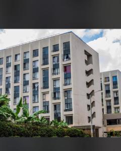 a large white building with windows on the side of it at one bedroom airbnb with swimmingpool, kiambu road in Kiambu