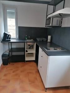 uma cozinha com um balcão preto e branco em Maisonnette indépendante em Morangis