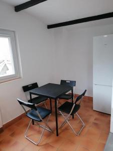 uma mesa preta e cadeiras num quarto com uma janela em Maisonnette indépendante em Morangis