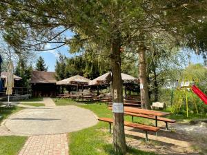 un parque con un árbol y bancos y un parque infantil en Izba MARTINA v Penzione pod Smrekom en Martin