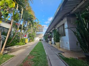 an empty sidewalk next to a building with palm trees at Arahra Hotel in Aparecida de Goiânia