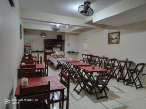 a restaurant with tables and chairs in a room at Arahra Hotel in Aparecida de Goiânia