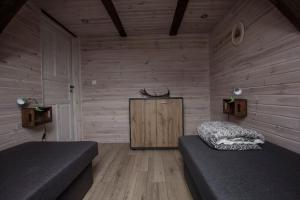 a room with two beds and a wooden wall at Apartament Agroturystyka Koniec Świata in Lesna