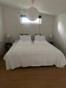 - un grand lit blanc dans une chambre avec fenêtre dans l'établissement Holiday home, by lake Simsjön and mountain Billingen, à Herrekvarn