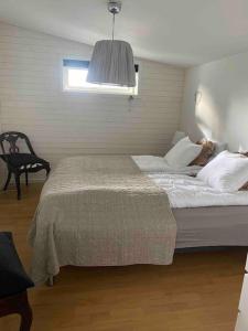 - une chambre avec un lit, une chaise et une fenêtre dans l'établissement Holiday home, by lake Simsjön and mountain Billingen, à Herrekvarn