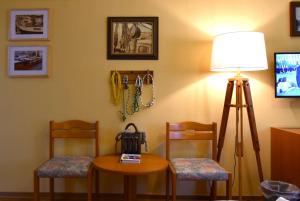um quarto com duas cadeiras, uma mesa e um candeeiro em Hotel-Restaurant Zum Goldenen Stern em Großalmerode