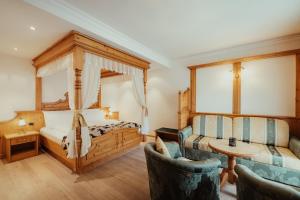 Schlafzimmer mit einem Bett, einem Tisch und Stühlen in der Unterkunft Hotel Alpenrose in Arabba