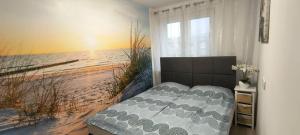 a bedroom with a bed in front of a beach at Costa del Hel in Hel