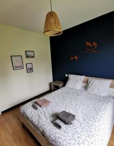 - une chambre dotée d'un lit avec un mur bleu dans l'établissement Calme entre pins et océan, à Onesse-et-Laharie