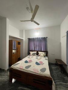1 dormitorio con 1 cama y ventilador de techo en Mount River Homestay, en Palakkad