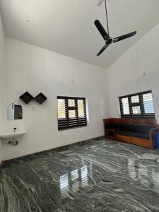 sala de estar con ventilador de techo y sofá en Mount River Homestay, en Palakkad