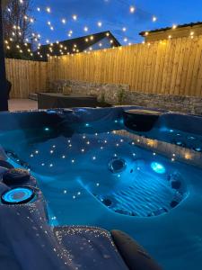 a hot tub in a backyard at night with lights at The Orchard, 5 Star Luxury Accommodation in Newcastle
