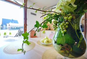 a vase filled with green grapes on a table at Apartments Sunshine - 650 metrów od plaży in Mielenko