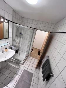 ein Bad mit einer Dusche und einem Waschbecken in der Unterkunft Apartment Hölderlin in Seevetal