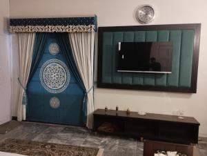 a living room with a television on a wall at Shelton House in Karachi +11 photos