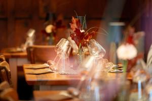 een tafel met wijnglazen en een vaas met bloemen bij stadtwirt bruck in Vöcklabruck