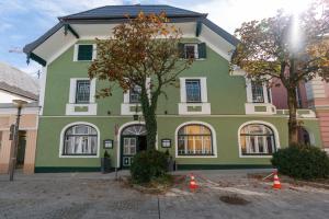 uma casa verde com cones laranjas à frente em stadtwirt bruck em Vöcklabruck