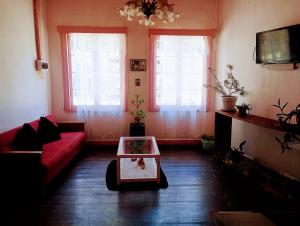 バルパライソにあるCasa Vista Hermosaのリビングルーム(赤いソファ、窓2つ付)