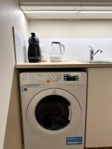 - un lave-linge sous un comptoir avec évier dans l'établissement Charm’Studio Cosy Suréquipé, à Colombes