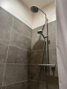 La salle de bains est pourvue d'une douche avec un pommeau de douche. dans l'établissement Charm’Studio Cosy Suréquipé, à Colombes