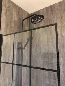 a shower with a glass door and a shower head at Home in Sheffield City Centre in Heeley