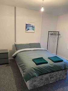 a bedroom with a bed with two green pillows on it at Home in Sheffield City Centre in Heeley