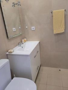 a bathroom with a toilet and a sink and a mirror at appartement in Charneca