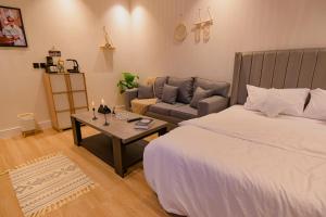 ein Schlafzimmer mit einem Bett, einem Sofa und einem Tisch in der Unterkunft استديو مودرن بمدخل ذاتي بجانب البوليڤارد in Riad