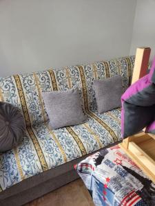 a couch with two pillows on it in a living room at appartement in Charneca