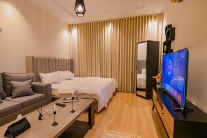 um quarto de hotel com uma cama e uma televisão de ecrã plano em استديو مودرن بمدخل ذاتي بجانب البوليڤارد em Riyadh
