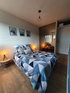 Un dormitorio con una cama azul y blanca en una habitación en Le Combo Parfait entre Mer et Nature, en Villers-sur-Mer