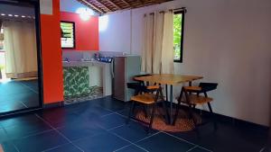 a kitchen with a table and chairs in a room at Le jardin des délices in Mahajanga