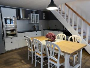 a kitchen with a table and chairs and a staircase at La ferme d'Auguste in Thorens-Glières