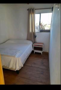 a small bedroom with a bed and a window at Cabaña Balneario buenos aires in Balneario Buenos Aires