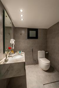 a bathroom with a toilet and a sink and a mirror at HDB Al Khobar Resort & Spa in Al Khobar