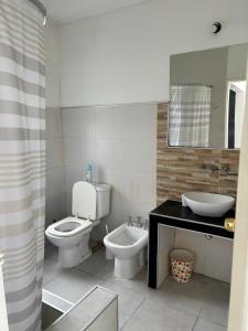 a bathroom with a toilet and a sink at Complejo Las Palmeras in Colonia del Sacramento