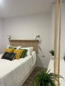 a bed with pillows on it in a room at Apartamento Verde en Sotogrande in Sotogrande +7 photos