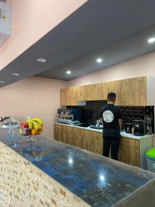 LARA BOUTIQUE HOTEL Antalya في لارا: رجل واقف في مطبخ مع كونتر