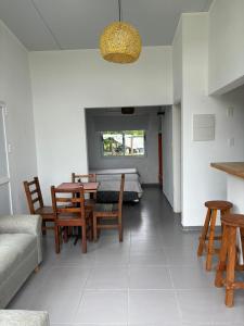 a living room with a table and chairs and a bed at Complejo Las Palmeras in Colonia del Sacramento