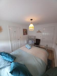 a bedroom with a large bed and a chandelier at Laurel Apartment in Bourton on the Water