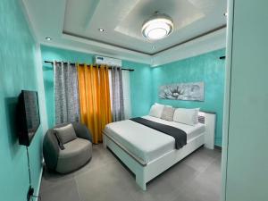 ein Schlafzimmer mit einem Bett und einem Stuhl in der Unterkunft Precious Palace in Accra
