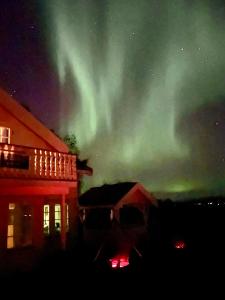 una imagen de una aurora en el cielo sobre un edificio en Centrally Located Cabin by the Sea - Sortland, en Sortland