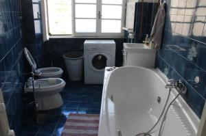 a bathroom with a tub and a toilet and a washing machine at Appartamento 5 stelle in Piazza Asti - Re di Roma - in Rome +2 photos