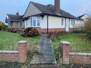 a house with a brick path in front of it at Oadby Town Mid-Century Bungalow in Oadby