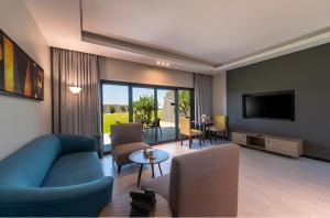 a living room with a blue couch and a tv at HDB Al Khobar Resort & Spa in Al Khobar