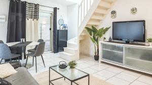 a living room with a large television and a table at Smart Confort 10 - Appartement confort et stylé in Troyes
