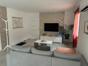 a living room with a couch and a tv at vacances en Ardéche "maison Chauvet" in Vallon-Pont-dʼArc